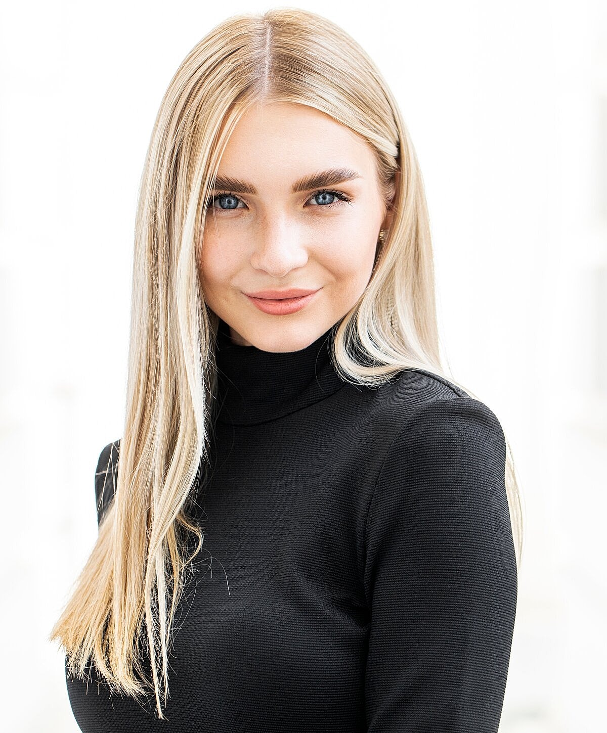 Woman examining lips in mirror at clinic.