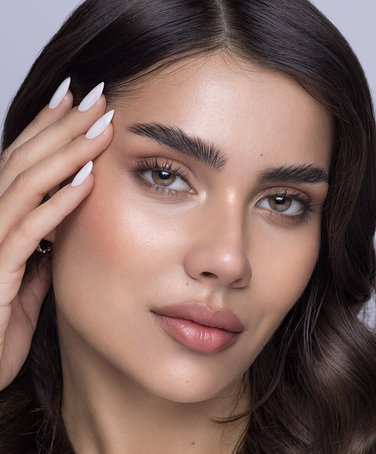 Woman examining lips in mirror at clinic.