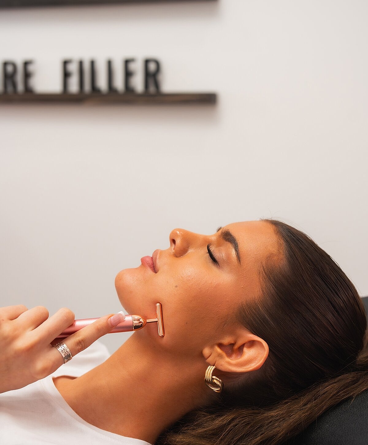 Woman examining lips in mirror at clinic.