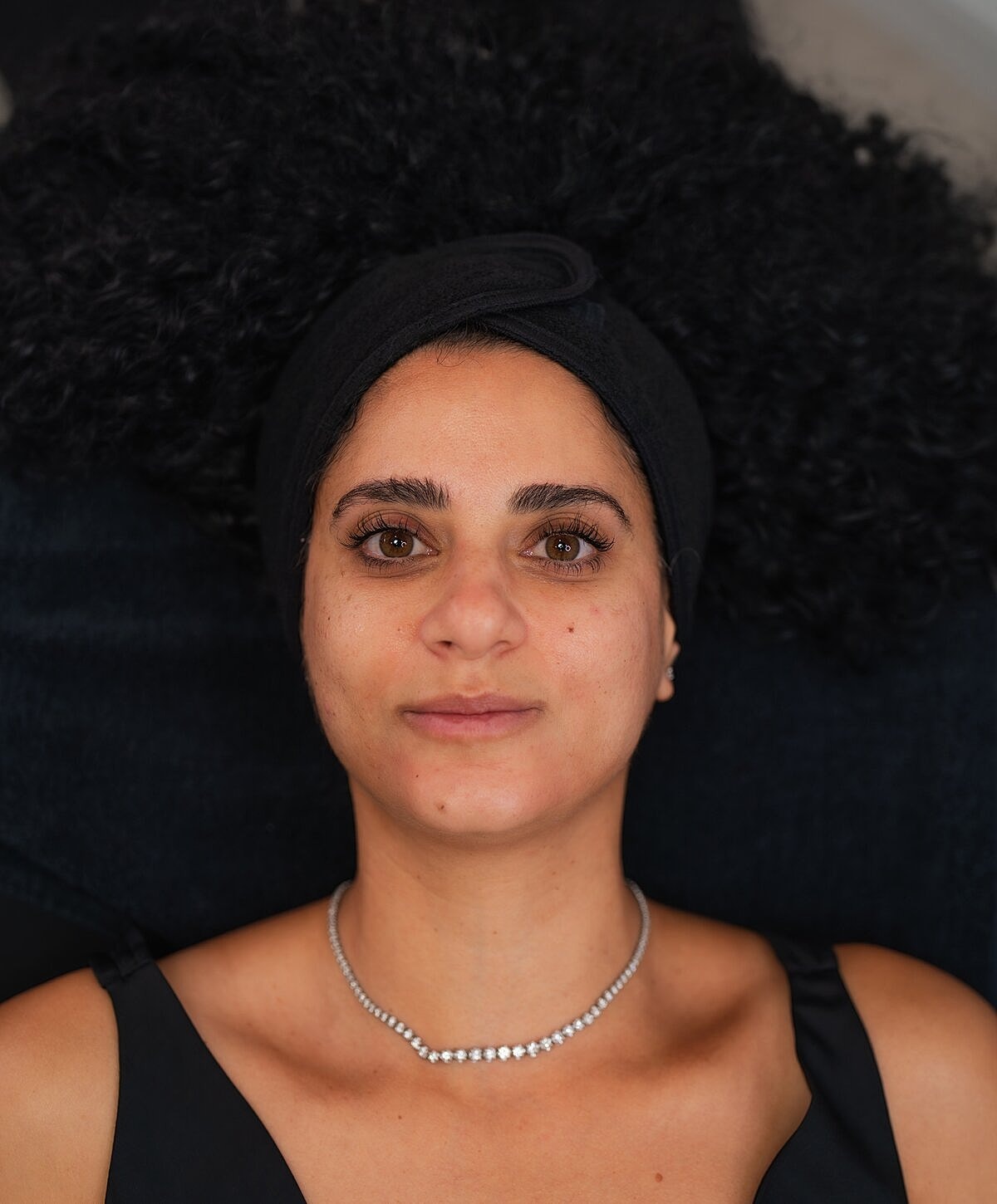 Woman examining lips in mirror at clinic.