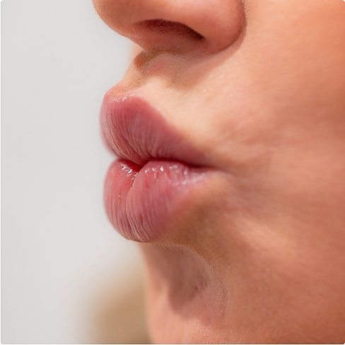 Close-up of lips about to kiss.